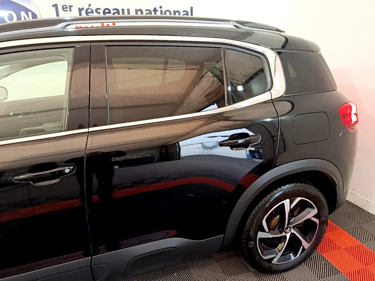 Vue côté droit arrière du Citroën C5 Aircross Hybrid noir, mettant en valeur les jantes alliage et les vitres teintées.
