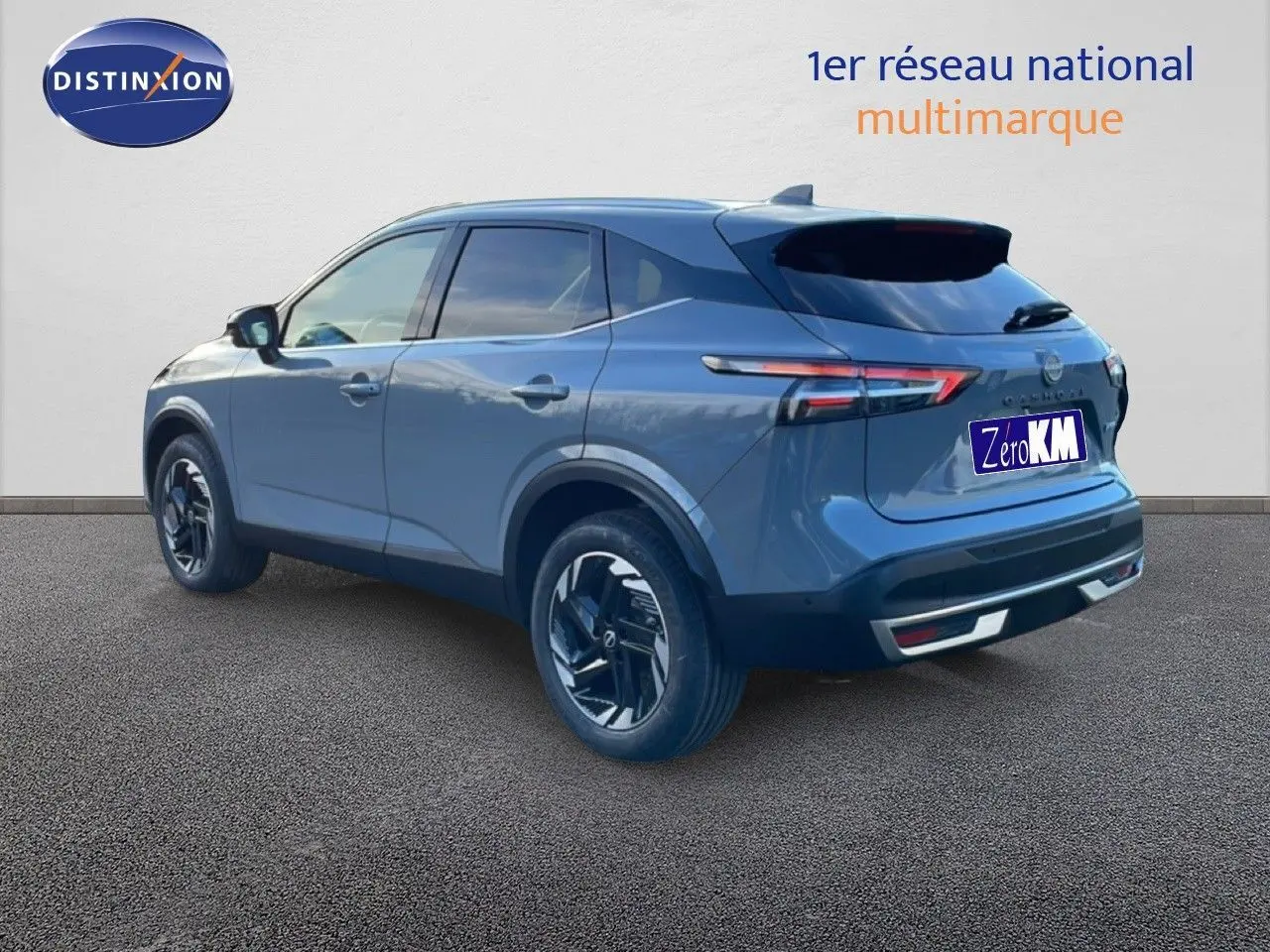 Vue 3/4 arrière droite du Nissan Qashqai gris argile métal avec jantes noires et feux arrière LED fins.