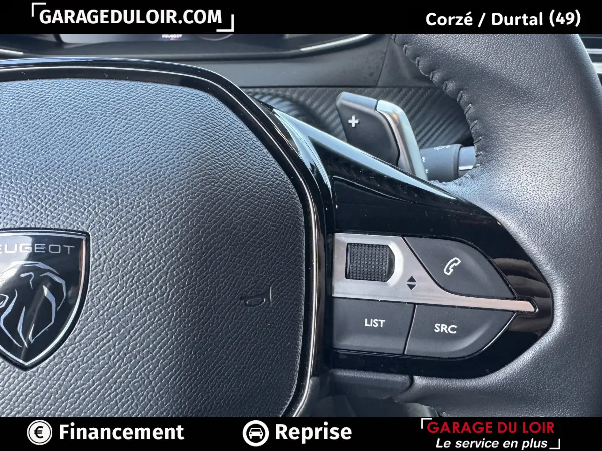 Gros plan sur le volant cuir multifonctions noir du Peugeot 208 Hybrid 110, avec commandes intégrées côté droit.