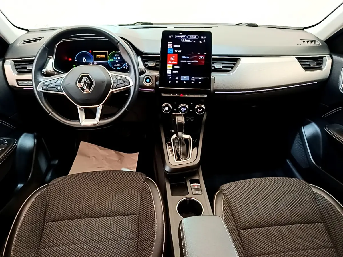 Vue intérieure avant du Renault Arkana Techno E-Tech 2023, tableau de bord noir avec écran tactile vertical et volant multifonctions.
