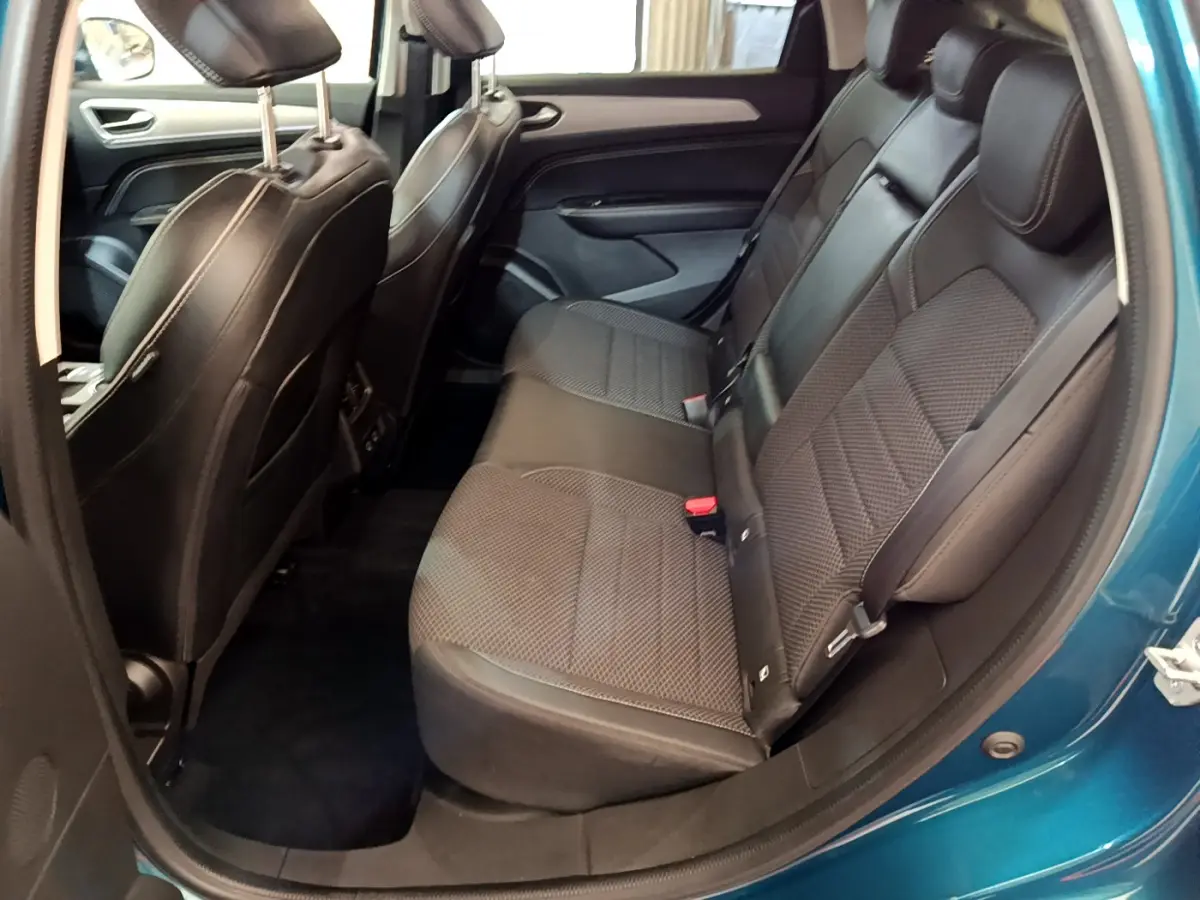Vue intérieure côté droit des sièges arrière en cuir noir du Renault Arkana bleu, montrant l'espace et la finition des assises.