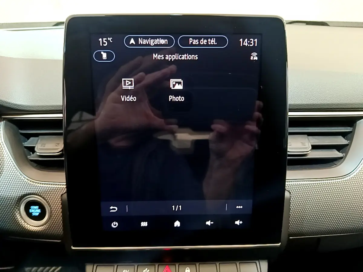 Écran tactile central de la Renault Arkana Techno E-Tech 145 bleu, affichant les applications vidéo et photo.