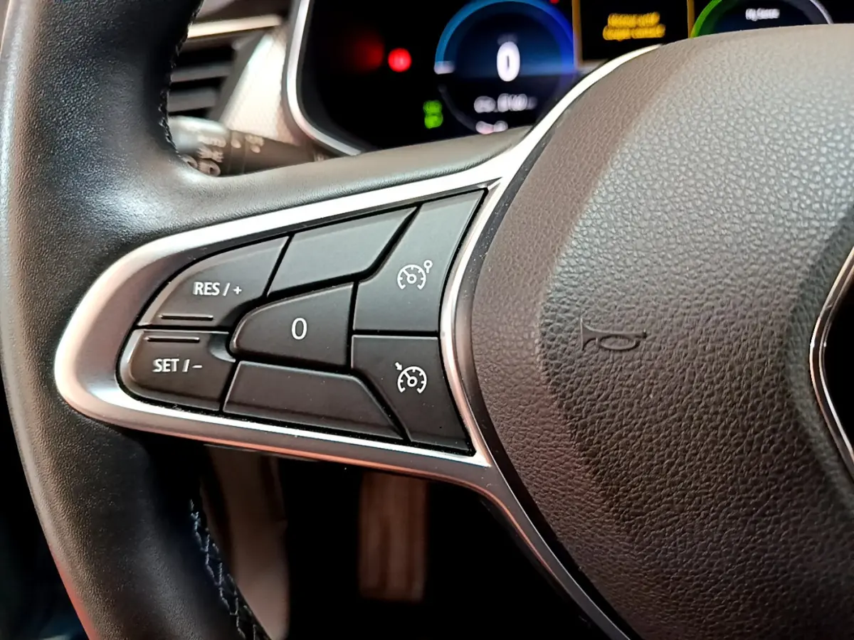 Gros plan sur la partie gauche du volant noir du Renault Arkana 2023 avec commandes de régulateur de vitesse.