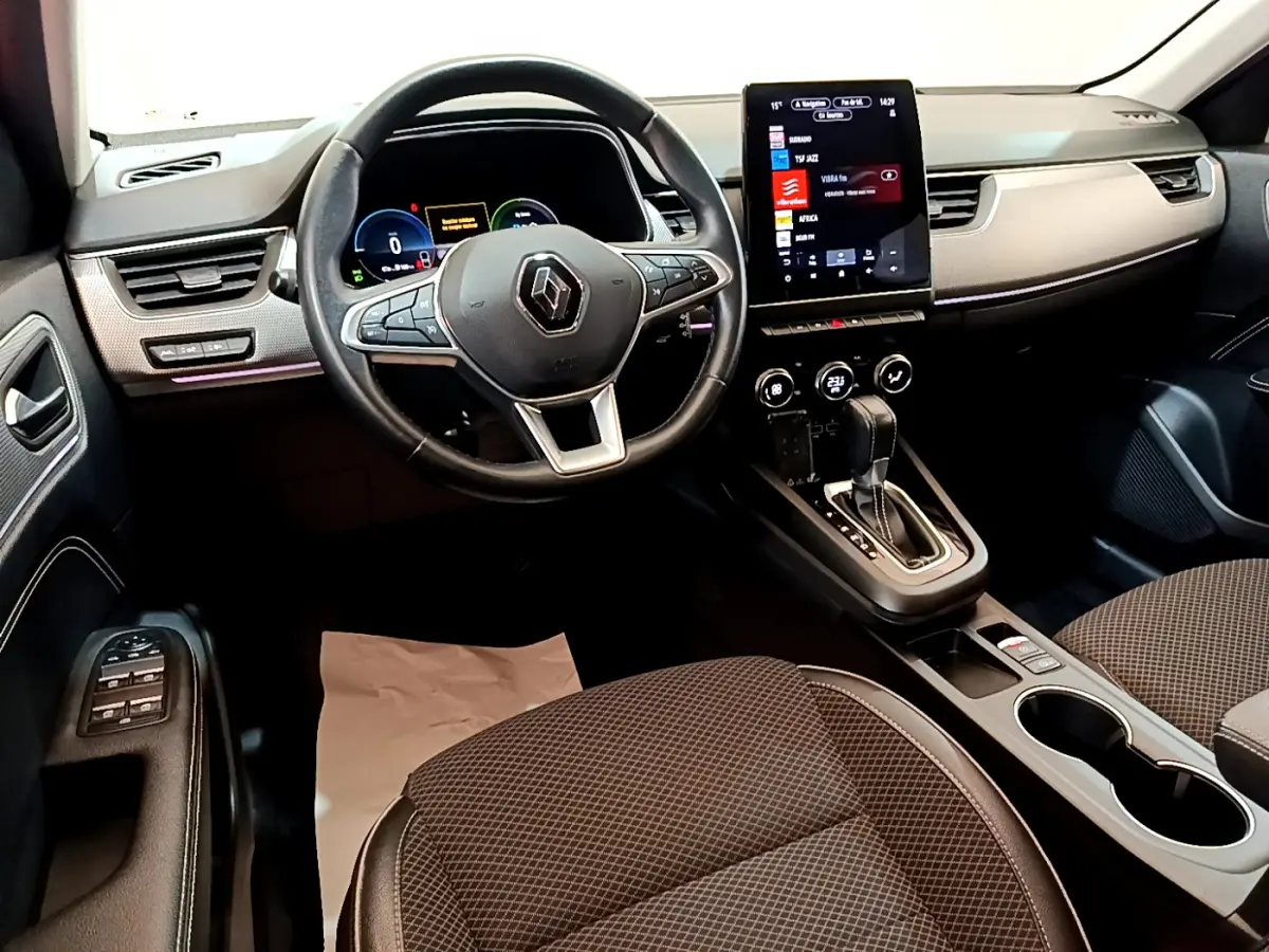 Vue intérieure avant droite du Renault Arkana bleu 2023, volant cuir, écran tactile vertical et console centrale avec levier de vitesse.