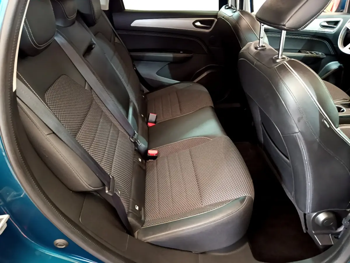 Vue intérieure côté arrière droit du Renault Arkana Techno E-Tech 145 bleu, sièges tissu noir avec surpiqûres blanches.