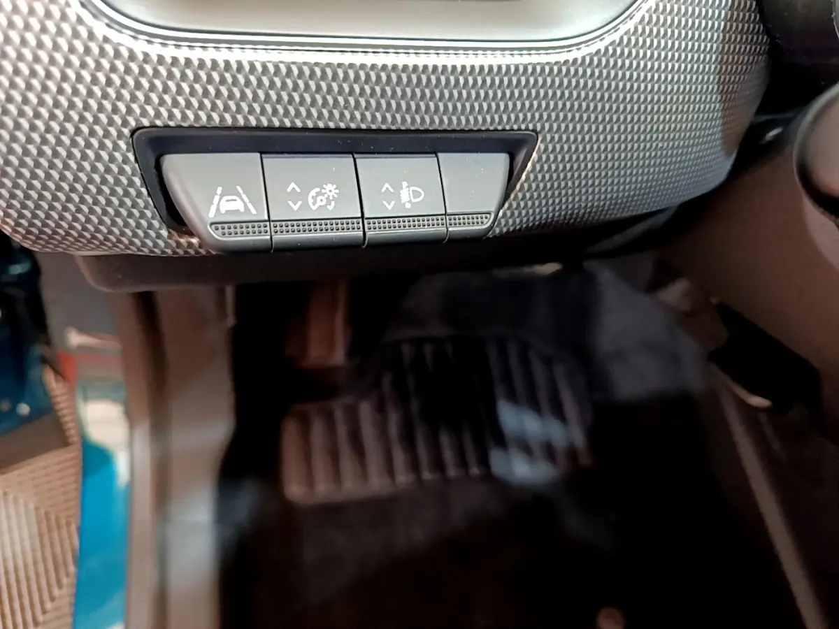 Gros plan sur les commandes d'assistance au conducteur sous le tableau de bord du Renault Arkana bleu 2023.