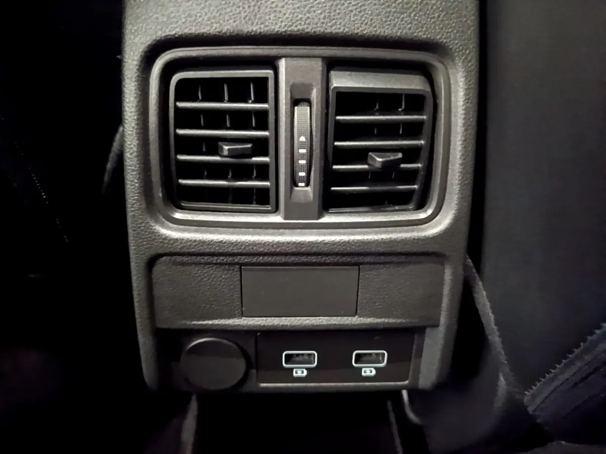Vue rapprochée de la console arrière noire avec bouches d’aération et deux ports USB du Renault Arkana bleu 2023.