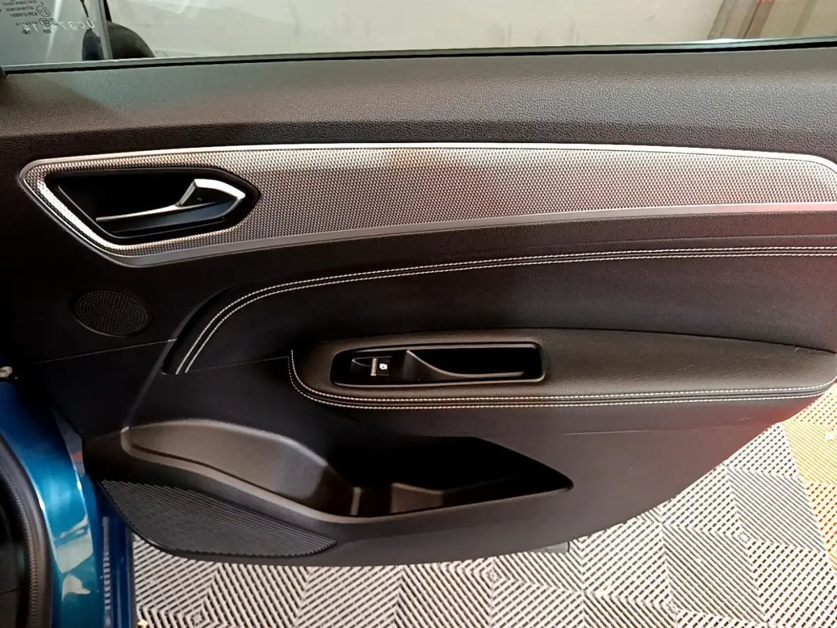 Vue intérieure côté gauche de la porte avant bleu Renault Arkana 2023, avec garniture noire et insert argenté.