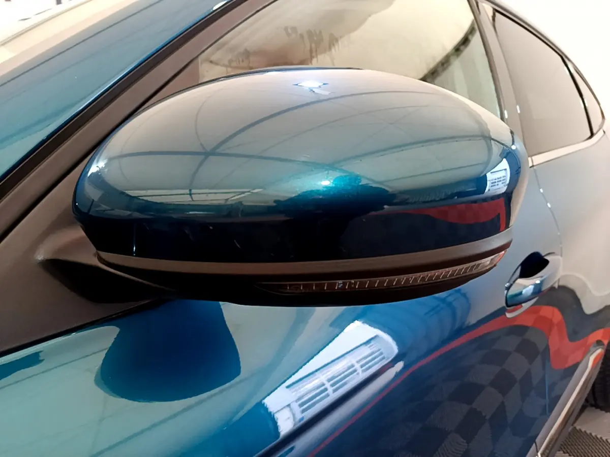 Rétroviseur droit bleu métallisé de Renault Arkana 2023 avec clignotant intégré, vue rapprochée côté conducteur.