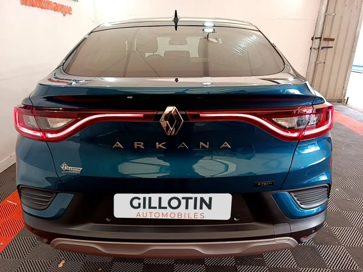 Vue arrière d'une Renault Arkana bleu avec feux LED en forme de vague et logo central chromé.