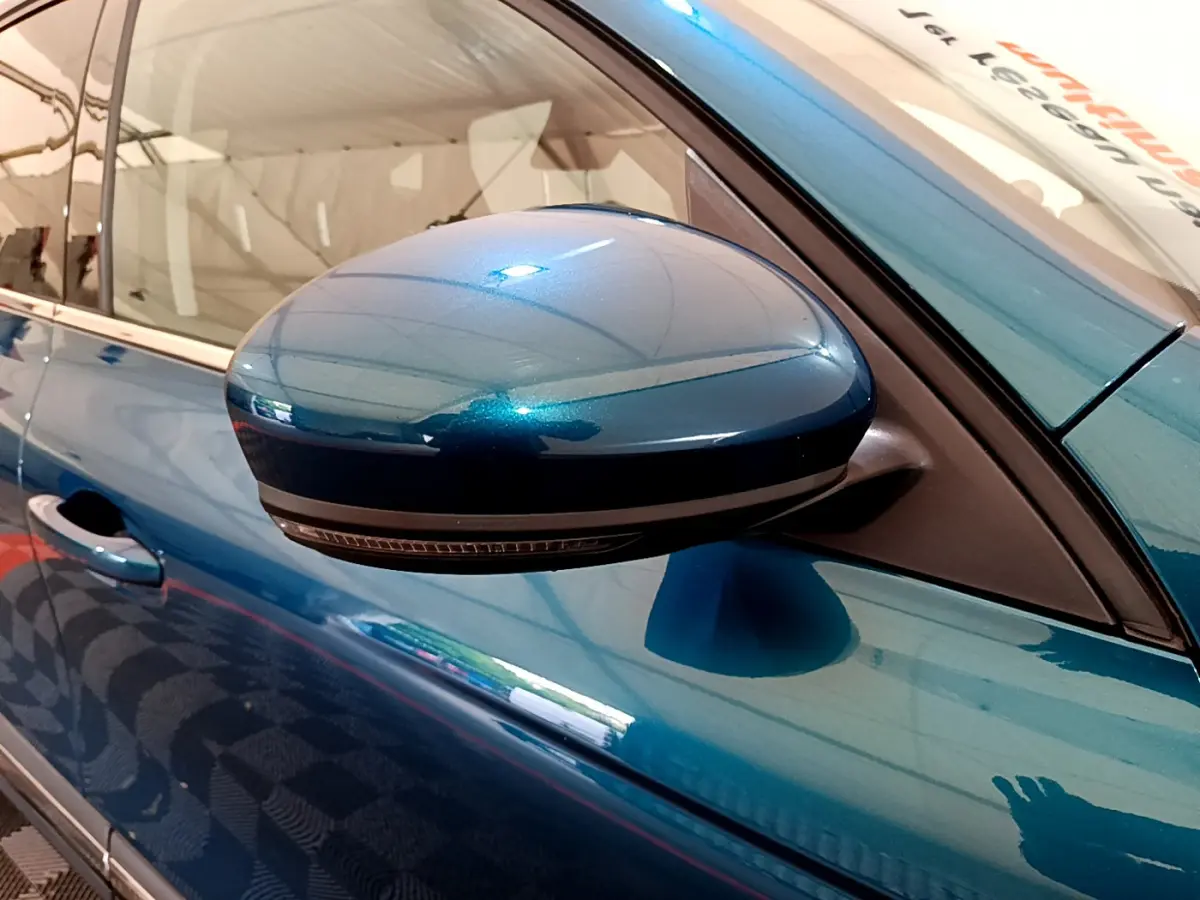 Rétroviseur côté gauche bleu métallisé de Renault Arkana 2023, avec clignotant intégré, vue rapprochée.