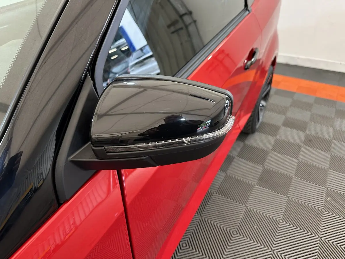 Gros plan sur le rétroviseur extérieur côté conducteur noir brillant de l'AIXAM AMBITION rouge 2025.