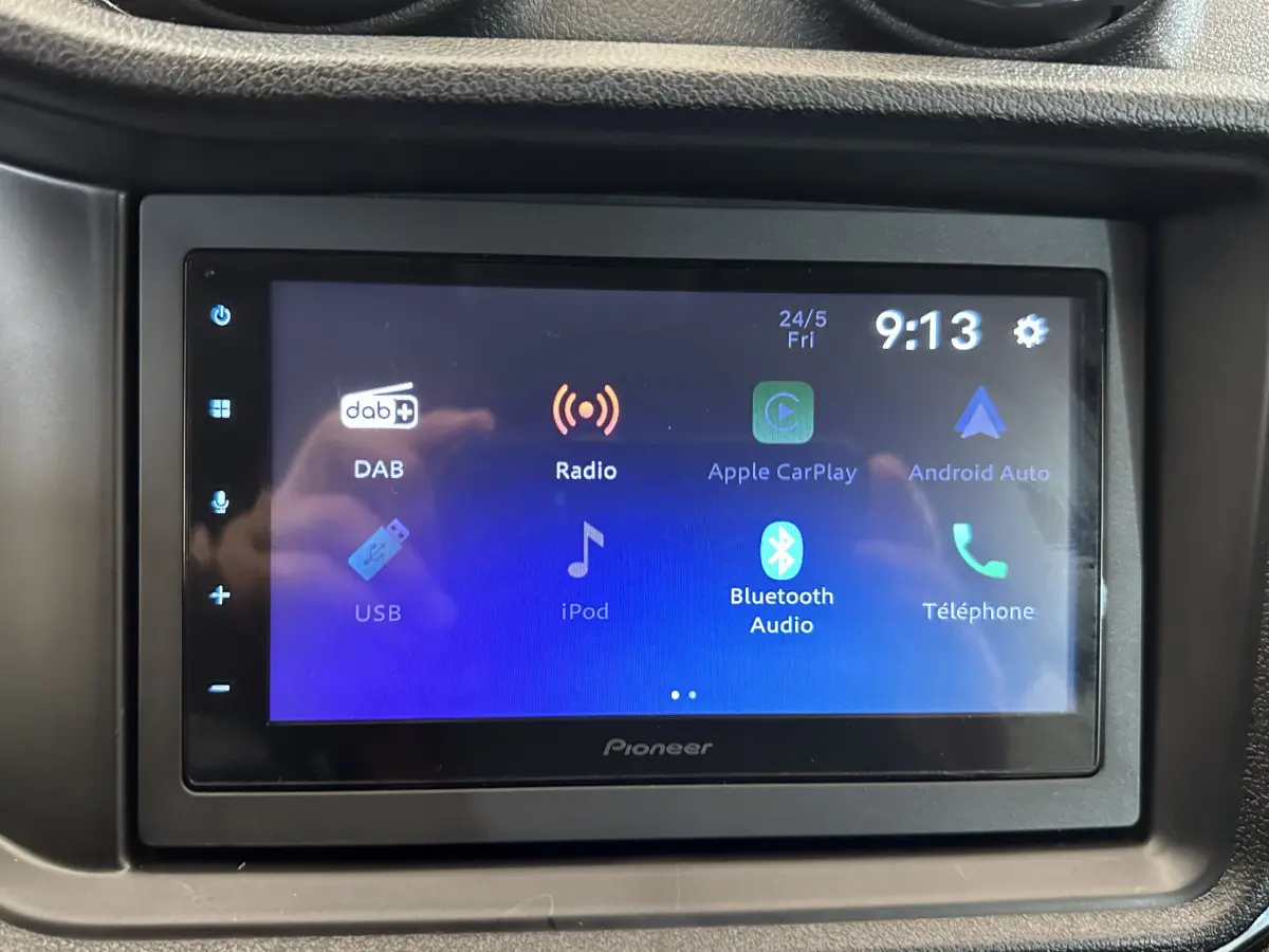 Écran tactile multimédia Pioneer affichant les options radio, Apple CarPlay, Android Auto et Bluetooth dans l'habitacle d'une Aixam Ambition rouge.