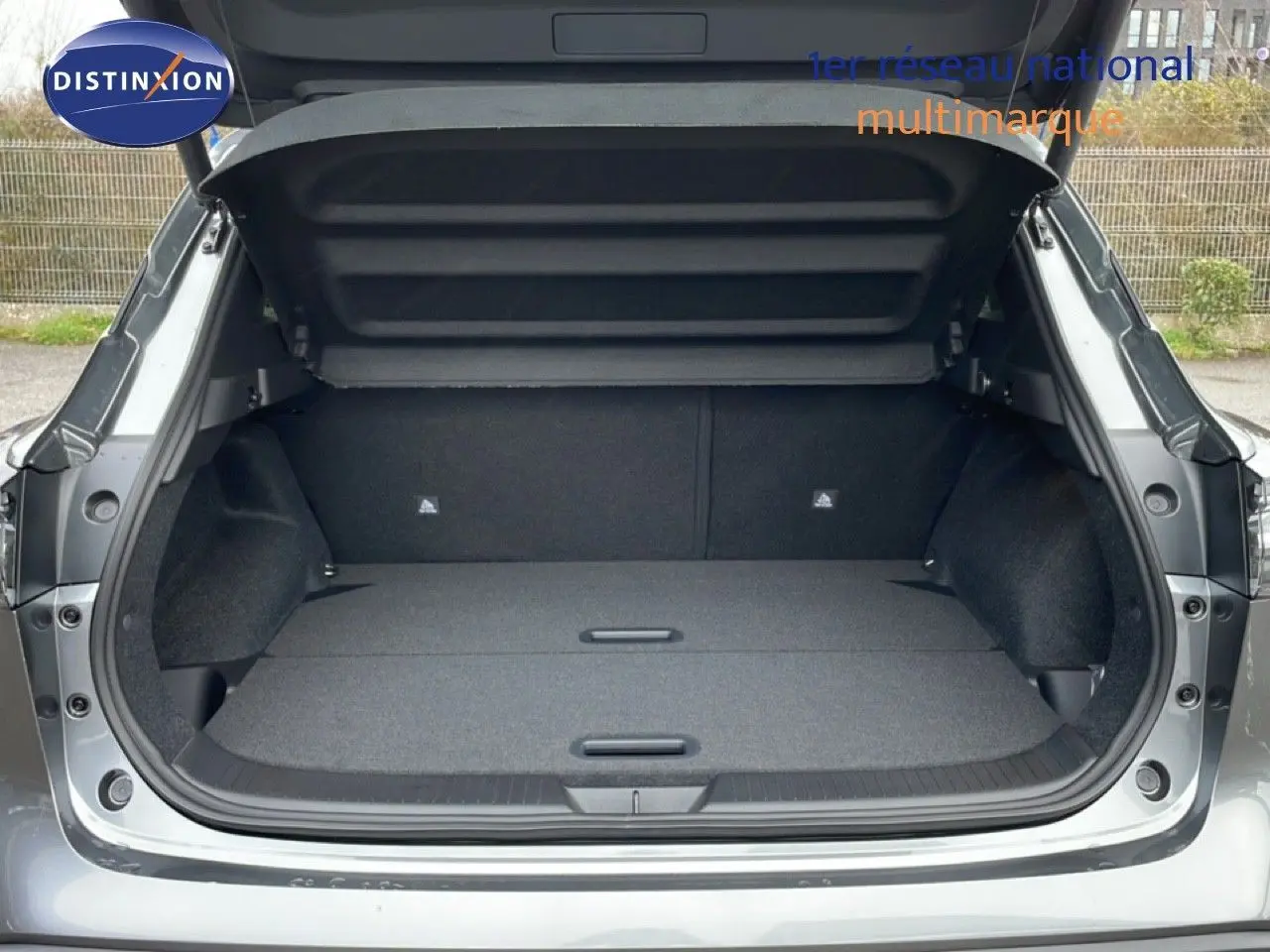 Coffre ouvert du Nissan Qashqai gris squale metal, vue arrière montrant un espace de chargement plat et spacieux.