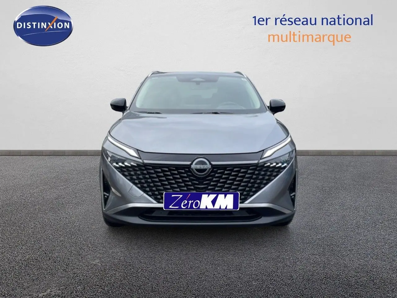 Vue frontale d'un Nissan Qashqai 2025 gris squale métal avec calandre noire et phares LED fins.