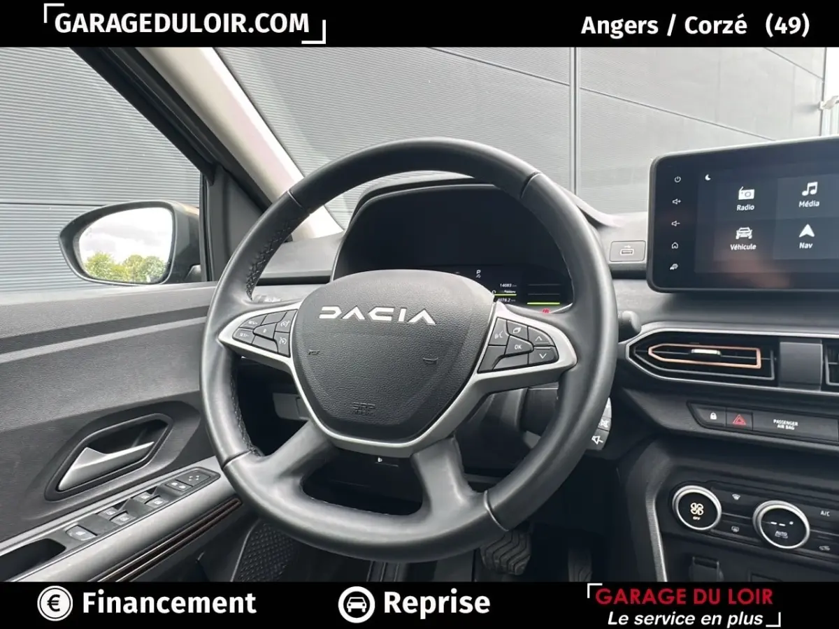 Vue intérieure centrée sur le volant noir du Dacia Jogger Extreme+ Hybrid 140 2025 avec tableau de bord et écran tactile visible.