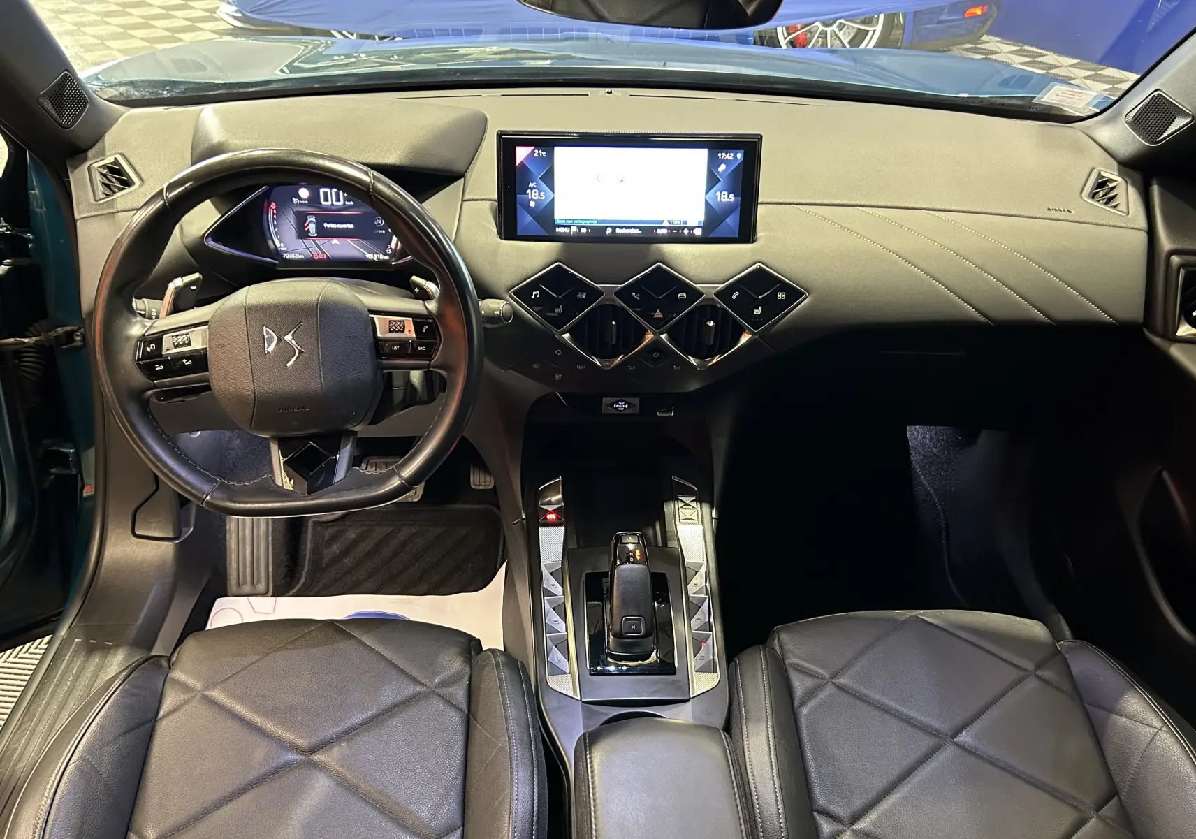 Vue intérieure frontale du tableau de bord et volant cuir noir du DS3 Crossback Bleu Millenium avec écran tactile et sièges chauffants.
