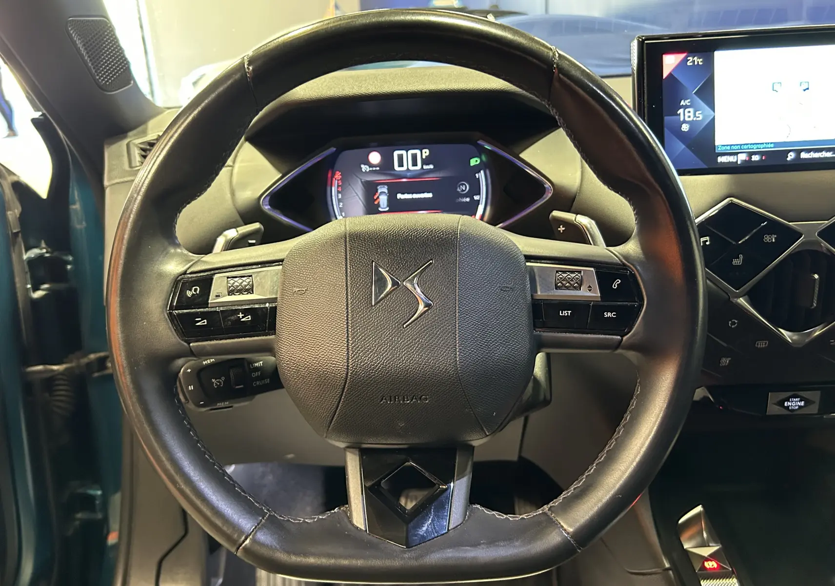 Vue rapprochée du volant cuir noir du DS3 Crossback Bleu Millenium avec tableau de bord numérique et écran central tactile.