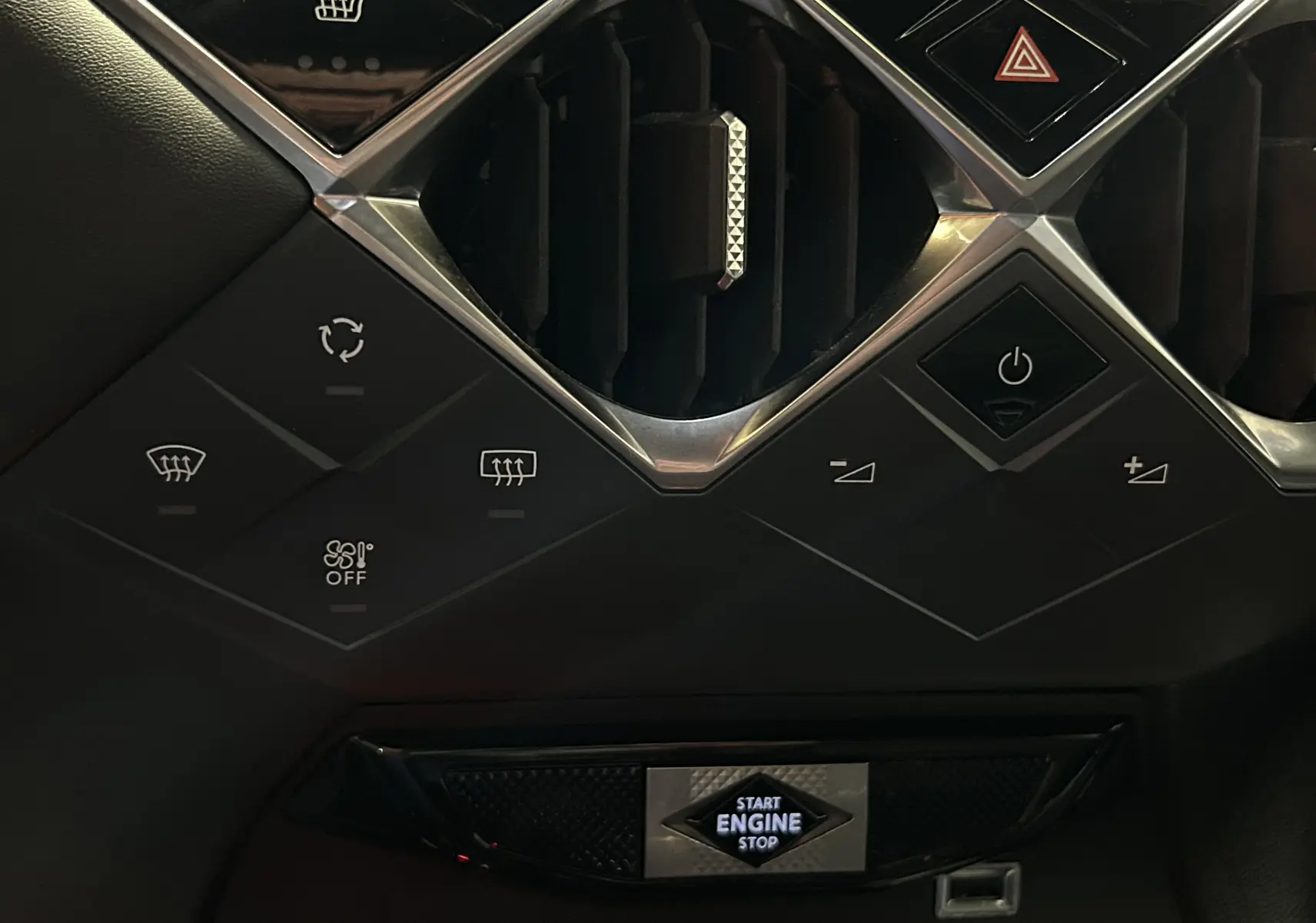 Détail du tableau de bord du DS3 Crossback bleu Millenium, avec commandes climatisation et bouton start/stop éclairé.