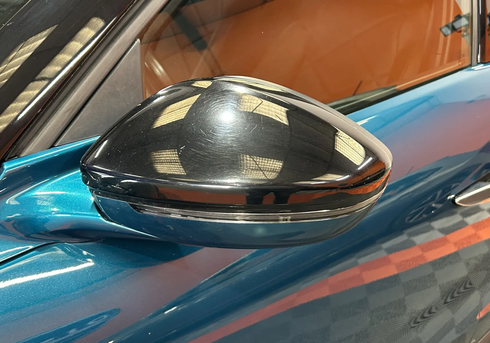 Gros plan sur le rétroviseur noir brillant côté gauche d'une DS3 Crossback Bleu Millenium, avec reflet intérieur visible.