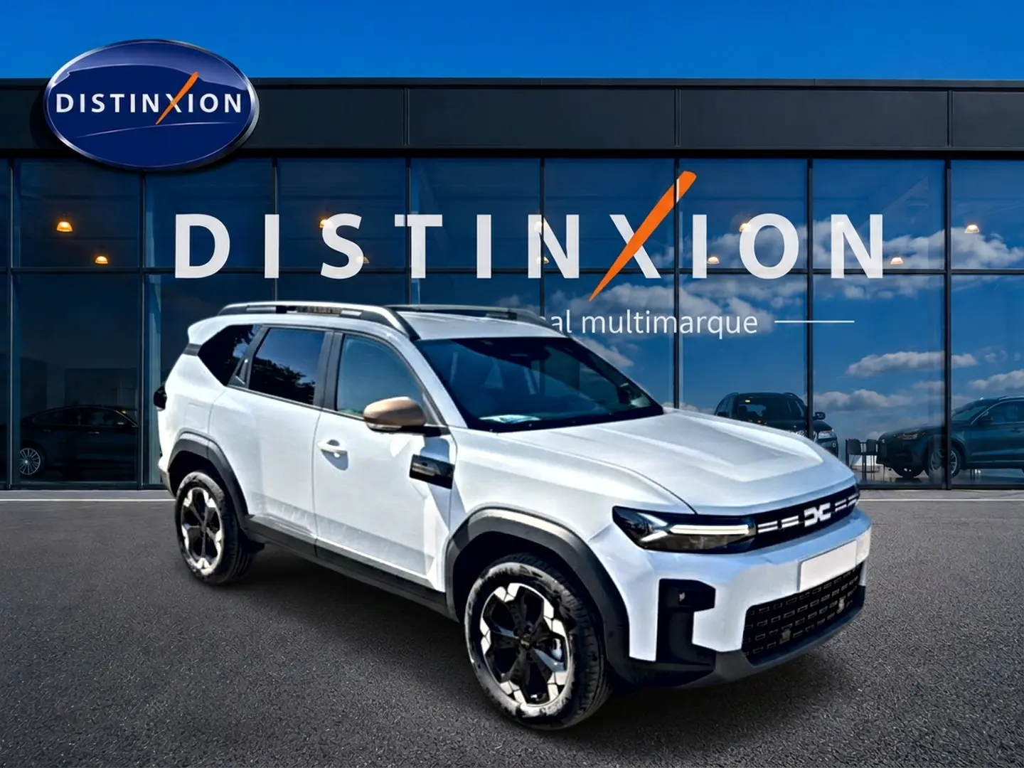 SUV Dacia Bigster blanc en 3/4 avant droit, avec barres de toit et jantes alu noires et argentées.