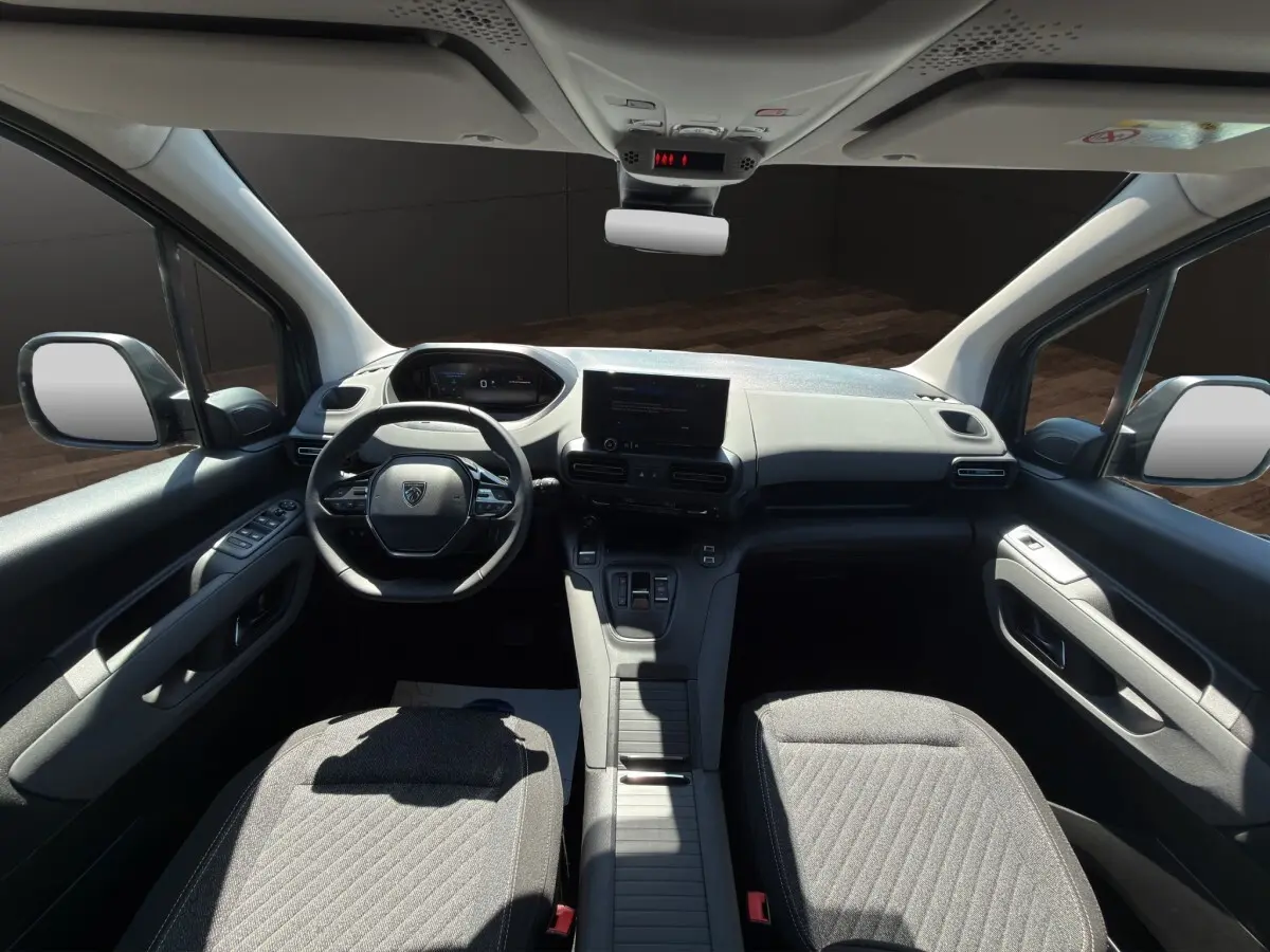 Vue intérieure avant du Peugeot Rifter 2026 avec tableau de bord moderne, volant compact et sièges gris.