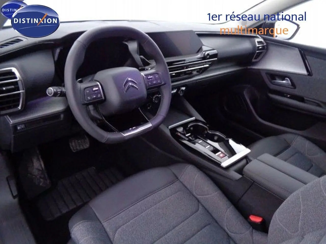 Intérieur noir de la Citroën C5 X 2022, vue du poste de conduite avec volant multifonction et console centrale moderne.