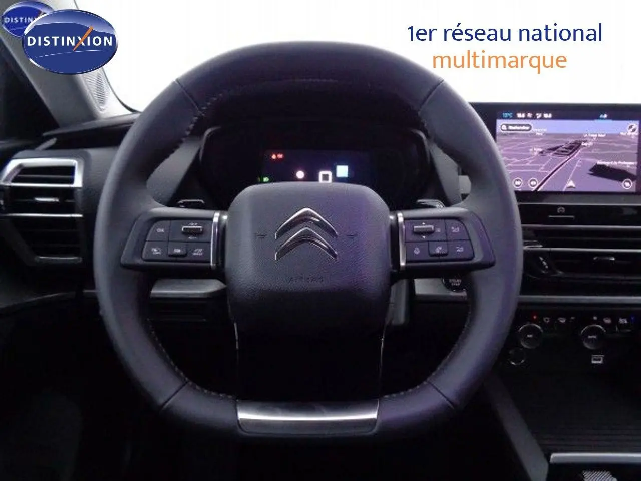 Vue rapprochée du volant cuir de la Citroën C5 X 2022 avec tableau de bord numérique et écran tactile de navigation.