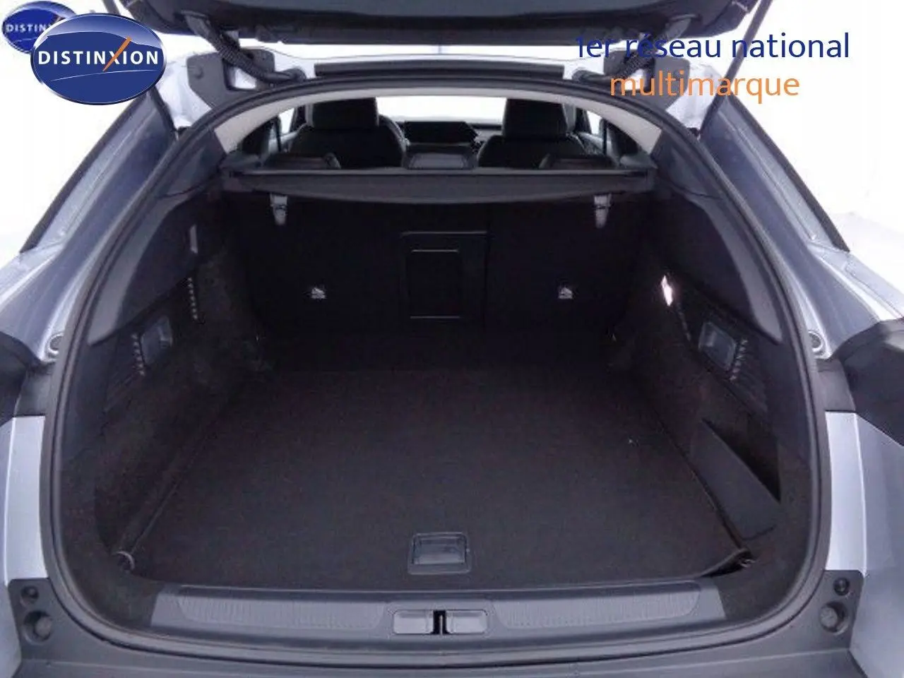 Coffre ouvert vu de l'arrière d'une Citroën C5 X gris Artense métal, montrant un espace de chargement spacieux et noir.