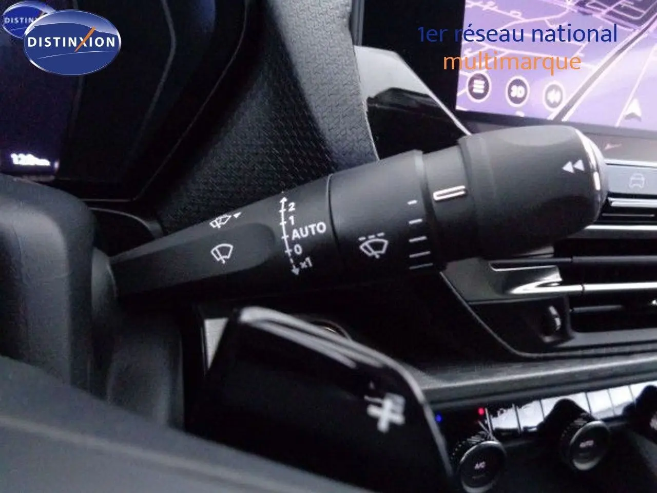 Gros plan sur la commande des essuie-glaces dans l'habitacle du Citroën C5 X gris Artense 2022 avec écran tactile en arrière-plan.