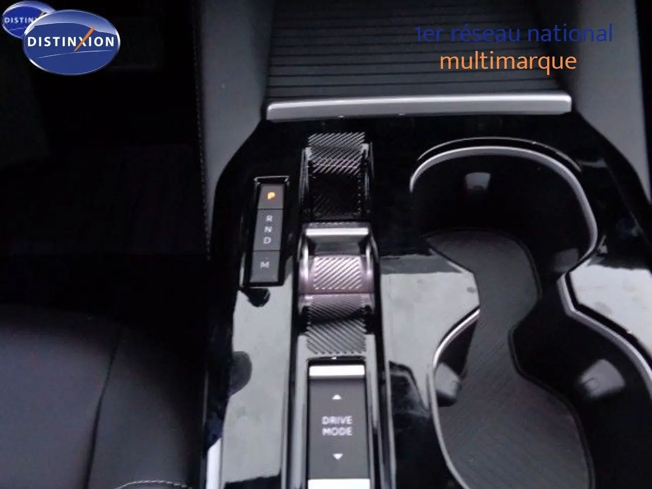 Gros plan sur la console centrale noire brillante de la Citroën C5 X gris Artense, mettant en valeur la commande de boîte automatique et les porte-gobelets.