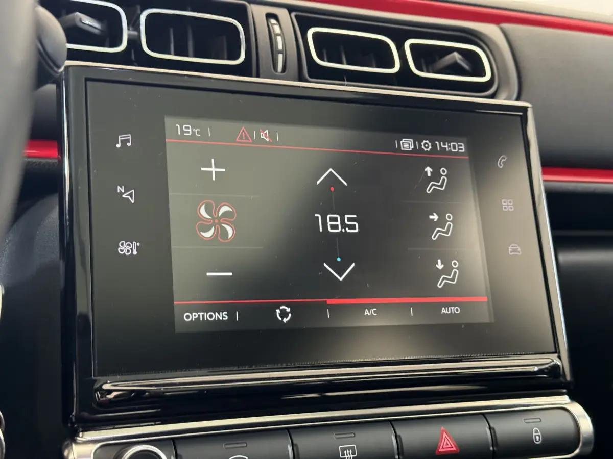 Écran tactile central affichant la climatisation à 18,5°C dans l'habitacle noir de la Citroën C3 Shine Business.