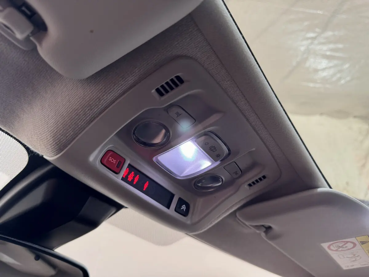 Plafonnier intérieur allumé avec commandes et bouton SOS dans une Citroën C3 noire de 2019.