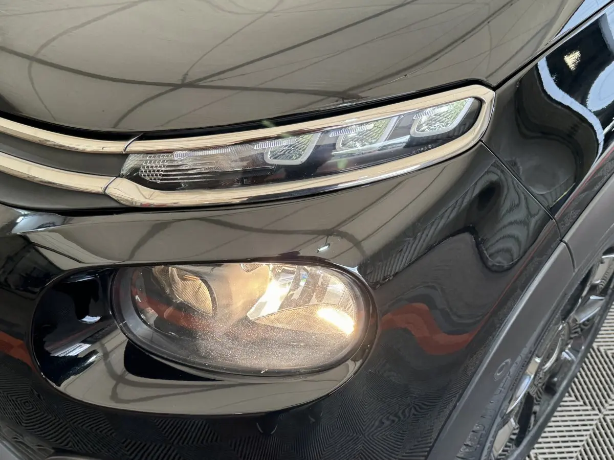 Gros plan sur le phare avant droit noir brillant d'une Citroën C3 2019 avec feux LED et antibrouillard intégré.