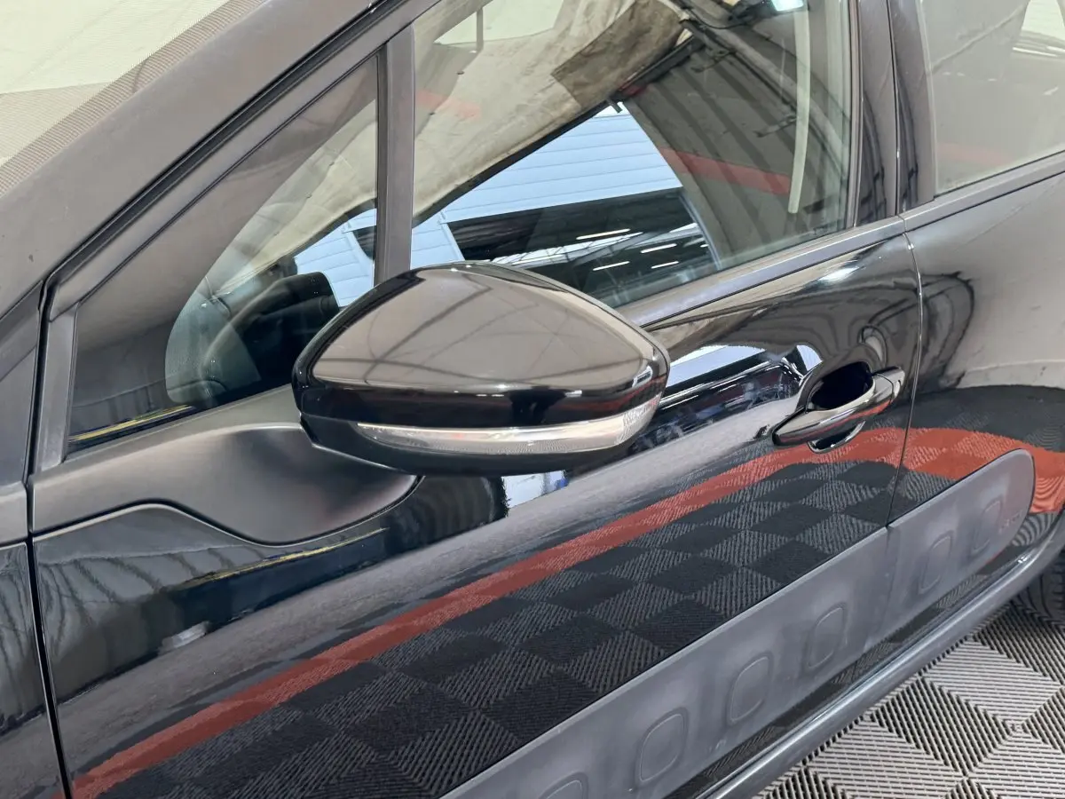 Gros plan sur le rétroviseur côté gauche et la porte noire brillante d'une Citroën C3 Shine Business 2019.