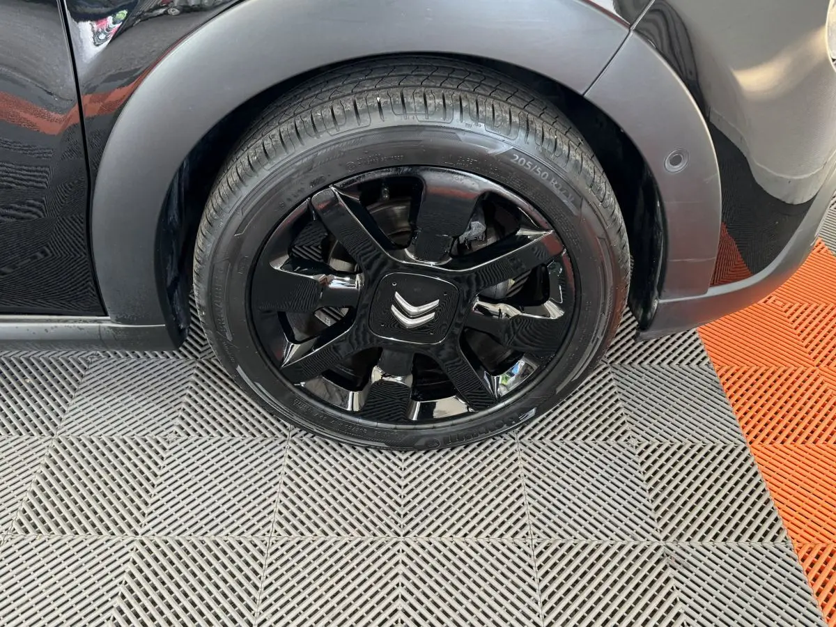 Gros plan sur la roue avant droite noire d'une Citroën C3 2019 avec jante noire brillante et logo Citroën central.