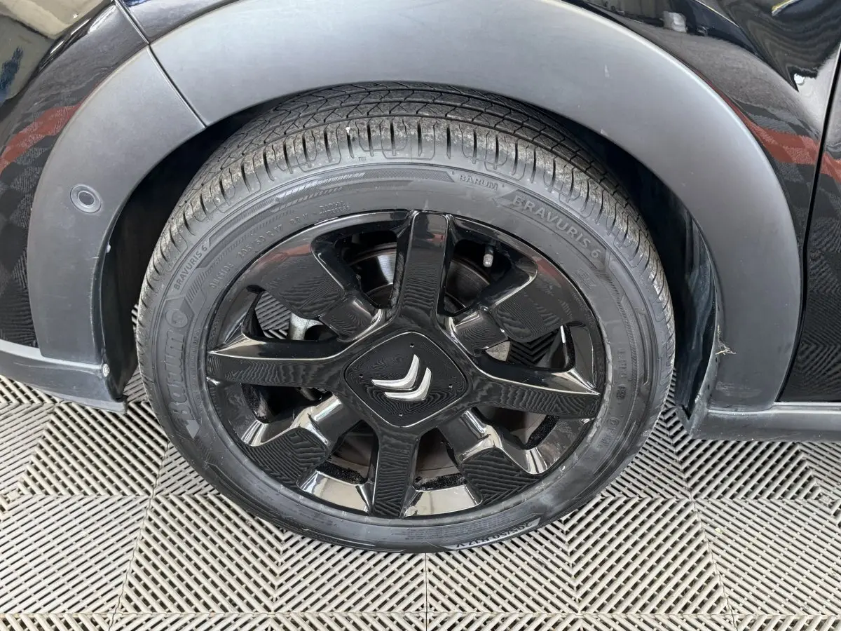 Gros plan sur la roue avant gauche noire d'une Citroën C3 2019 avec jante noire brillante et logo Citroën central.