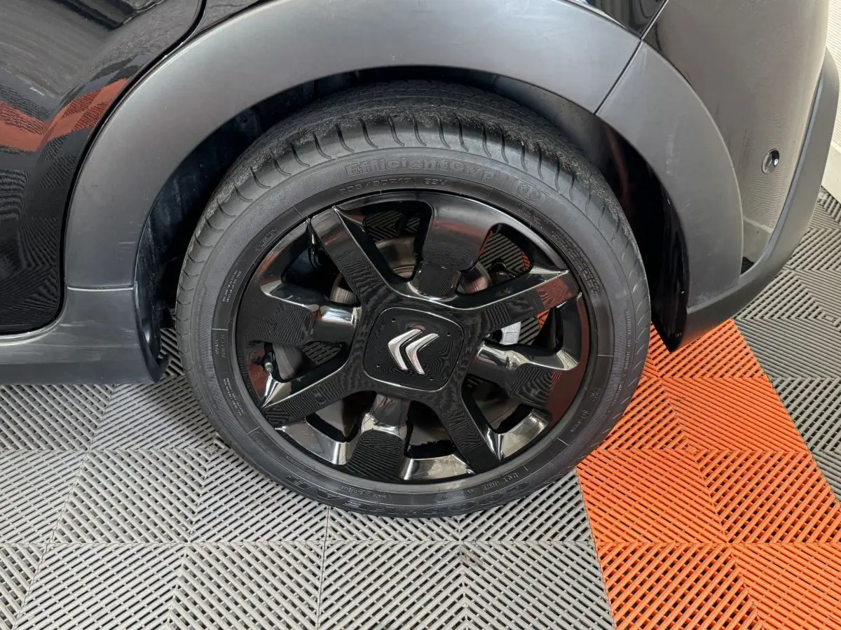 Gros plan sur la roue avant gauche noire d'une Citroën C3 2019 avec jante noire brillante et logo Citroën central.