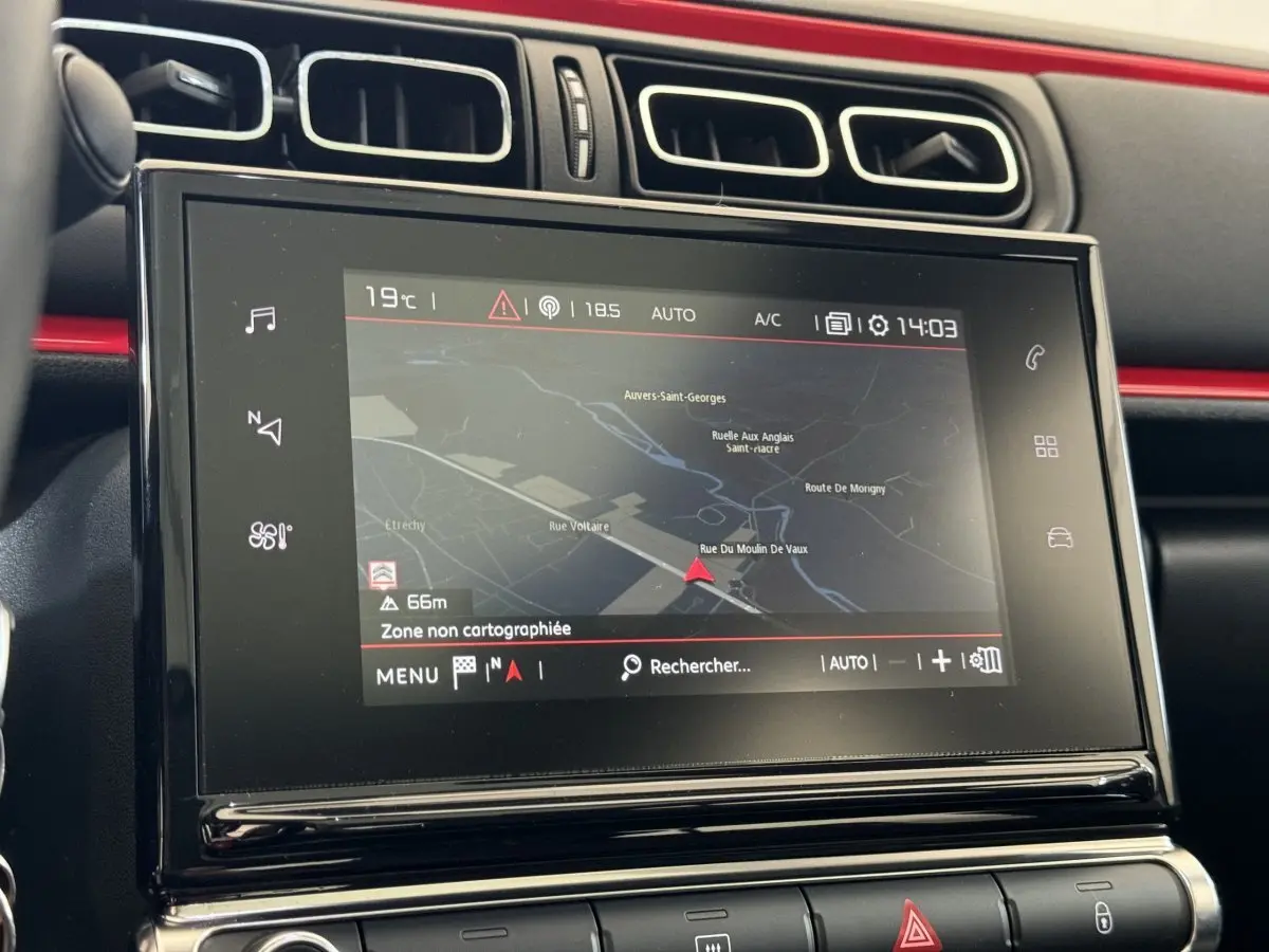 Écran tactile central de navigation dans l’habitacle noir et rouge d’une Citroën C3 2019 vue de face.
