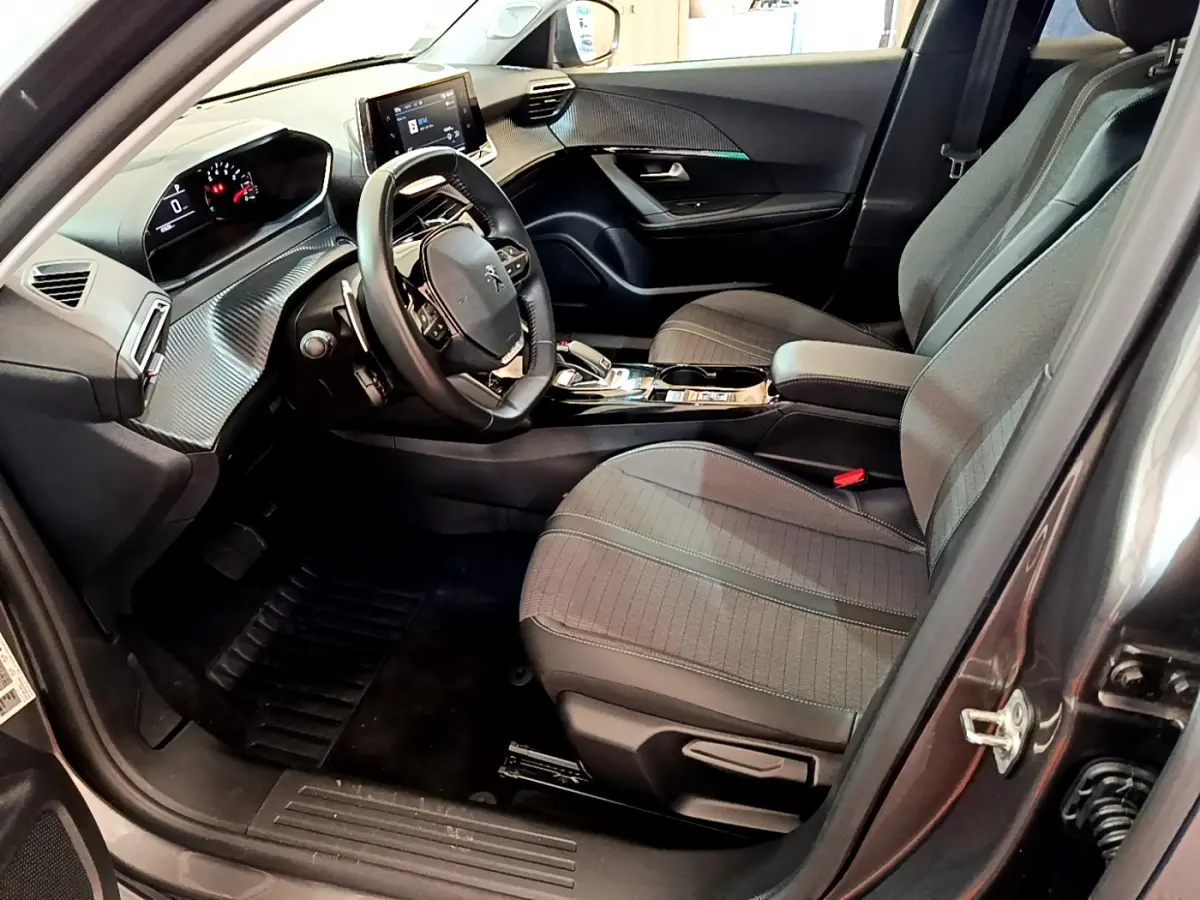 Intérieur gris foncé du Peugeot 2008 PureTech 130, vue côté conducteur avec tableau de bord et écran tactile visibles.