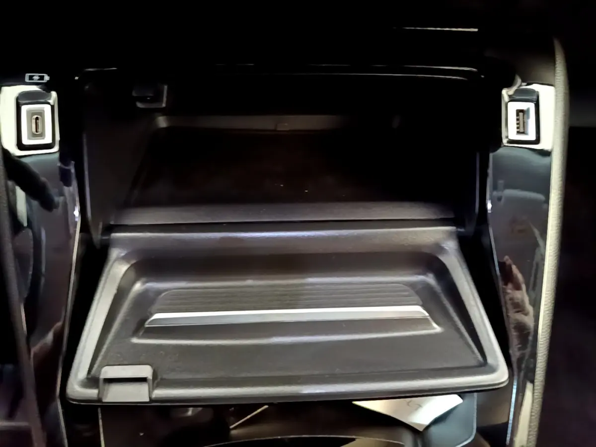 Gros plan sur la boîte à gants ouverte avec ports USB avant et arrière dans le Peugeot 2008 gris foncé 2022.