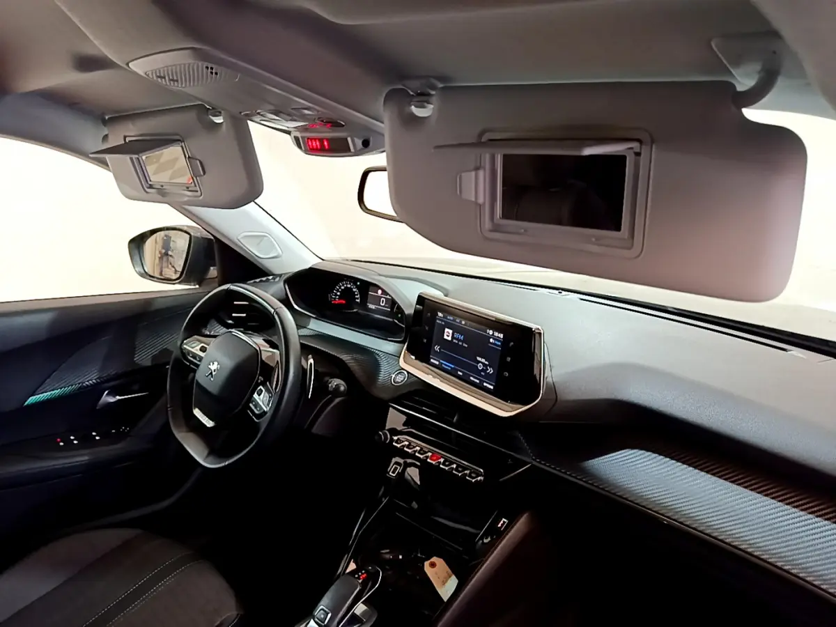 Intérieur Peugeot 2008 gris foncé vu côté conducteur, tableau de bord avec écran tactile et volant multifonctions cuir.