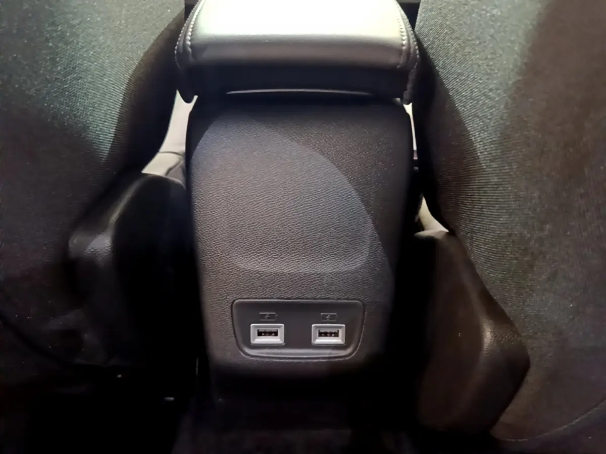 Vue rapprochée de la console centrale arrière noire du Peugeot 2008 avec deux ports USB visibles entre les sièges.