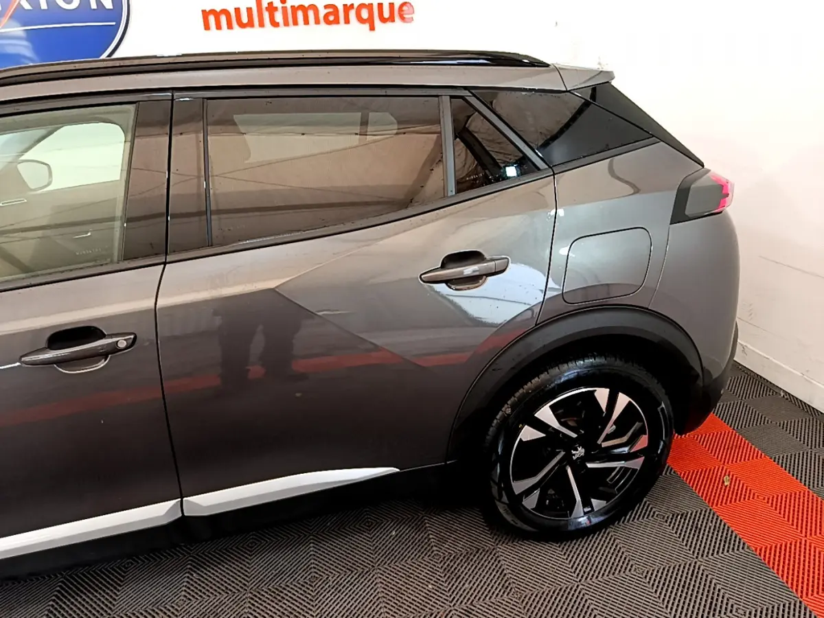 Vue côté droit arrière du Peugeot 2008 gris foncé 2022 avec jante alliage et lignes de caisse marquées.