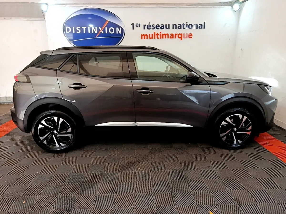 Peugeot 2008 gris foncé vue de profil côté droit, avec jantes noires et toit noir contrastant.