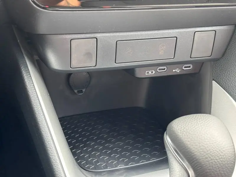 Détail de la console centrale de la Toyota Yaris 116h Dynamic 2025 montrant prises USB-C et prise 12V, finition noire.
