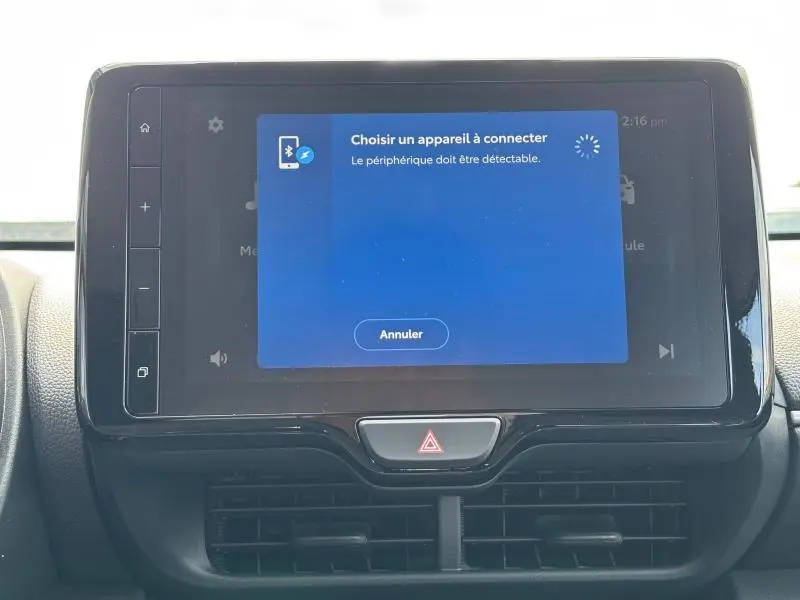 Écran tactile central de la Toyota Yaris 116h Dynamic blanc 2025 affichant la connexion Bluetooth en cours.