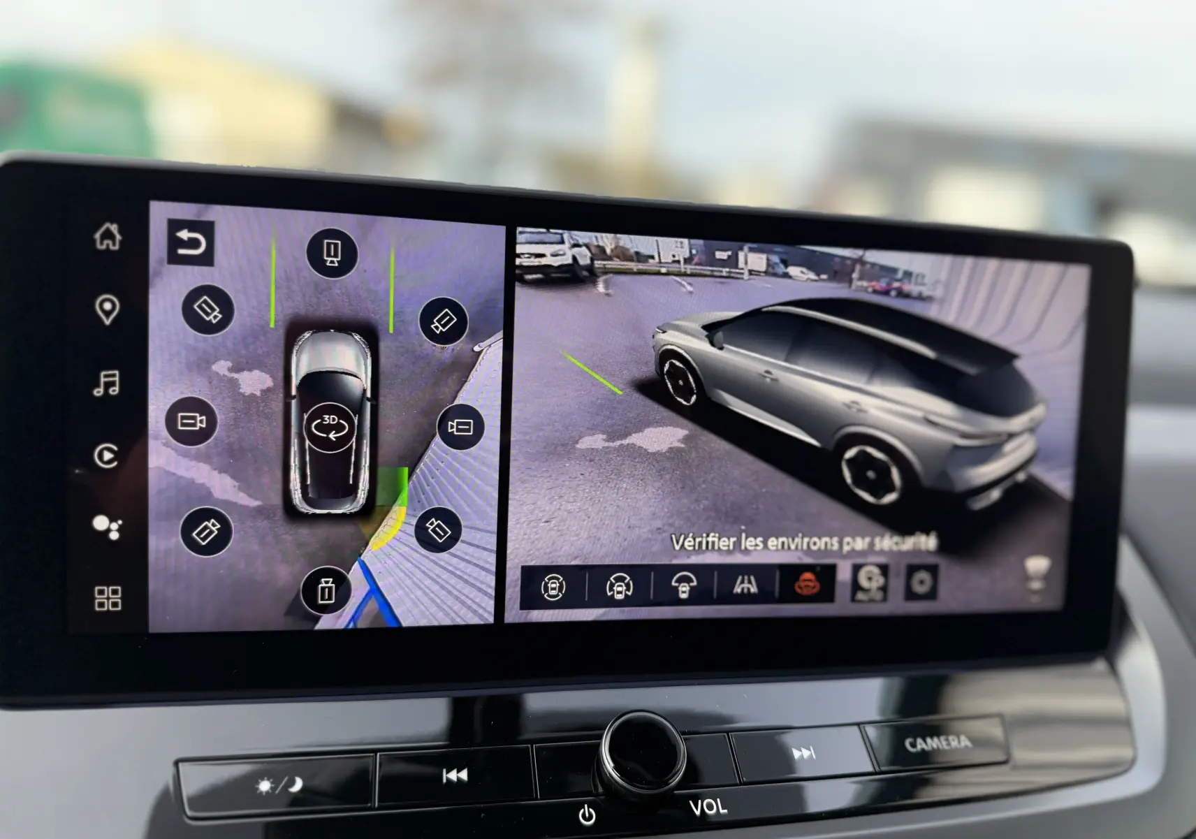 Écran multimédia affichant la vue 3D et la caméra 360 d’un Nissan Qashqai gris squale métal en stationnement.