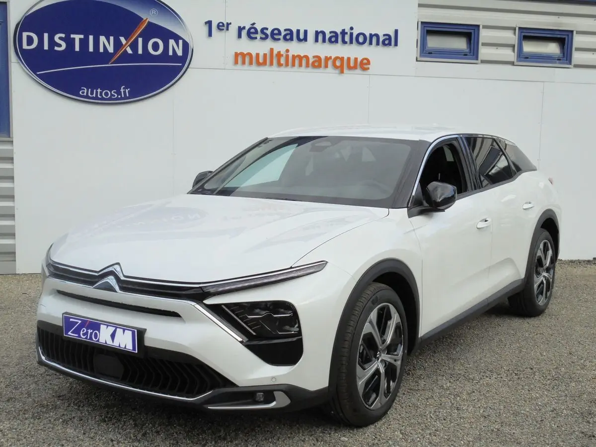 Citroën C5 X blanc nacré vue 3/4 avant droit avec calandre distinctive et jantes alliage modernes.