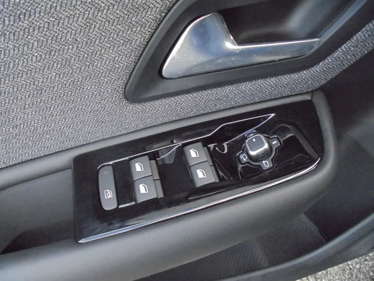 Gros plan sur les commandes de lève-vitres et rétroviseurs côté gauche d'une Citroën C5 X 2022, finition tissu gris.